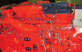 All Cummins ISX engines have the XPI common-rail injection system, which uses a crankshaft-driven pump to keep the fuel rail – seen of the left side of this 11.9L ISX – pressurized to more than 30,000 psi, providing full injection pressure to solenoid-activated injection nozzles in the head. Such systems provide maximum injection pressure even at low rpm and eliminate the need to adjust the injector rockers when doing overheads.