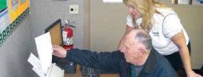 Cari Baylor, director of sales and IT for Milan, Ind.-based Baylor Trucking, helps company driver Carol Buckley with document management. To speed cash flow, the company uses an automated in-cab messaging system that tells drivers what documents they are missing each week.