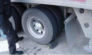 Safety inspections need to be carried out safely, so inspectors carry wheel chocks since service brakes must be checked with the parking brake off. Creepers allow them to move freely under tractor and trailer to check items such as brakes and suspensions.