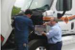 Wayne Beaudry, vice president of fleet maintenance for Maywood, N.J.-based Metropolitan Trucking, instructs a technician on parameter settings for a 2008 CARB-certified Detroit Diesel DD15 engine on a 2009 Freightliner Cascadia.