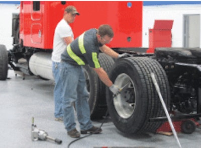 A fleet technician installs wide-base drive tires. Technicians can help find warning signs when something is wrong with the fleet’s tire selection process.