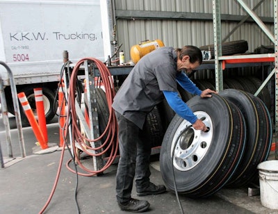 A technician for Pomona, Calif.-based KKW Trucking fills a truck tire with air. Proper inflation is critical for tires to enjoy a longer life.
