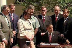 Trucking industry officials and Cabinet members join President Obama at the White House in 2011 as he signs the first-ever fuel efficiency standards for heavy-duty vehicles. (White House photo)