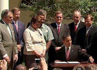 Trucking industry officials and Cabinet members join President Obama at the White House in 2011 as he signs the first-ever fuel efficiency standards for heavy-duty vehicles. (White House photo)