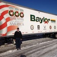 Baylor Trucking’s founder, Robert Baylor stands by a trailer that was used to deliver wreaths to military cemeteries.