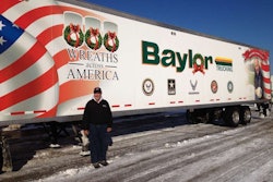 Baylor Trucking, Inc. President, Robert Baylor stands by the trailer which was used to deliver to several military cemeteries.