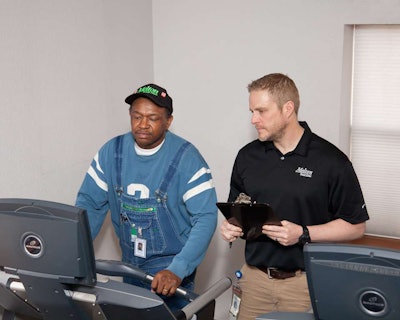 Bret Bringham, Melton’s wellness manager and personal trainer (right), works with a Melton employee on his health and wellness plan.