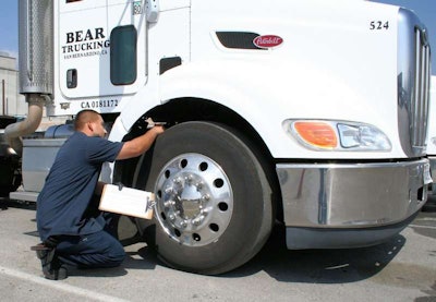 A technician for San Bernardino, Calif.-based Bear Trucking checks a Yokohama tire. As a tire rolls, there is less “squirm” with a shallow tread-depth tire than with a deep tread tire.