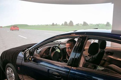 President Barack Obama prepares to drive a Saturn SL1 vehicle simulator during a tour of the Turner-Fairbank Highway Research Center in McLean, Va. Obama said Tuesday that the House passage of a bill to cover a shortfall in the Highway Trust Fund is just “kicking the can down the road.” (Official White House Photo by Amanda Lucidon)