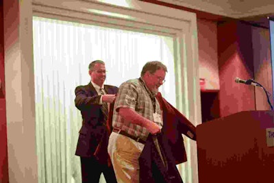 TCA President Brad Bentley helps Dean Newell with his jacket after Newell was named TCA’s Safety Professional of the Year.