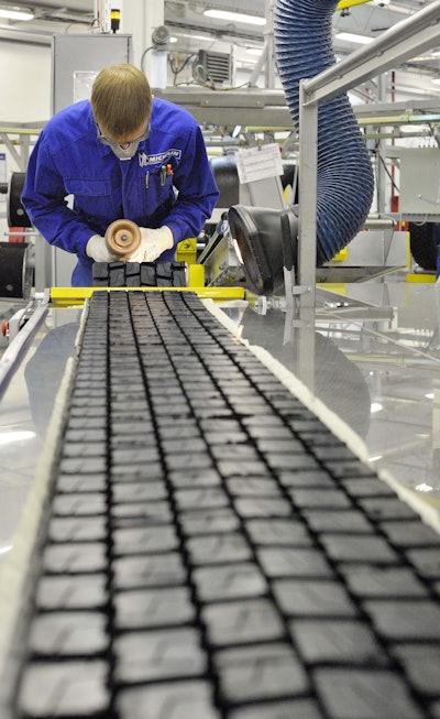 Michelin factory worker working on tire tread