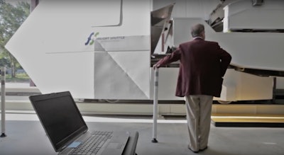 Texas A&M University Chancellor John Sharp stands in front of the university’s Freight Shuttle System prototype.