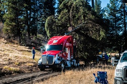 A crane loads the 80-foot Englemann Spruce that will serve as this year’s U.S. Capitol Christmas Tree onto Gary Amoth Trucking’s specially-decaled Kenworth T680.