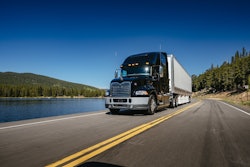 Semi truck driving on a road by the water