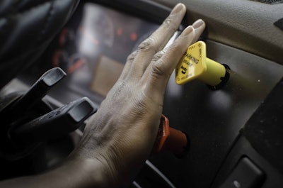 Trucker pressing parking button in truck
