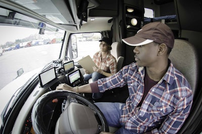 Truck driver with trainer in the cab of truck