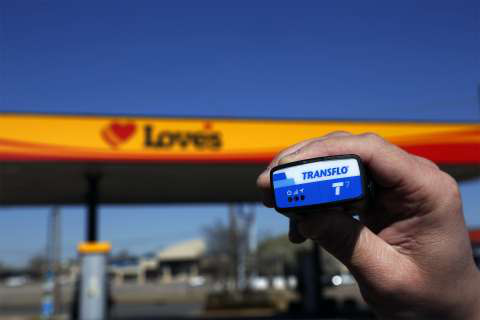Person holding a Transflo device in front of a Love's Travel Stop location