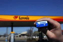 Person holding a Transflo device in front of a Love's Travel Stop location