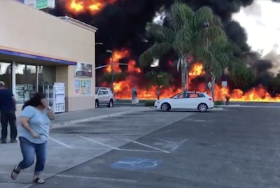 A woman runs from the site of a deadly tanker truck fire Tuesday in Atwater, Calif.