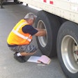 Truck driver checking truck tire