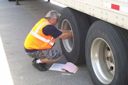 Truck driver checking truck tire