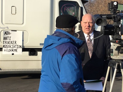 Owner-operator Douglas Hasner (right) speaks with a TV reporter at Monday’s event near Syracuse.