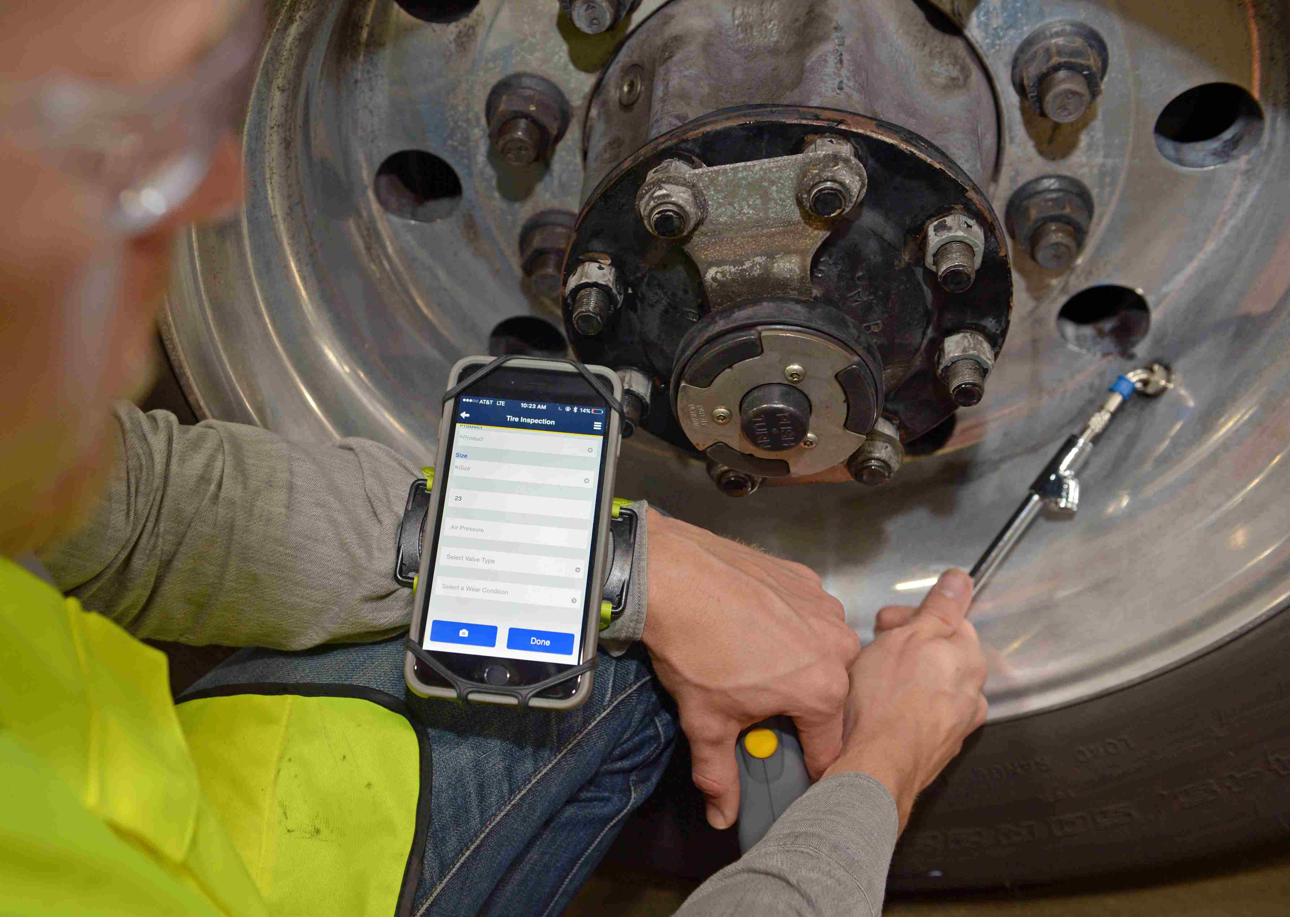 Technician using app while fixing tire