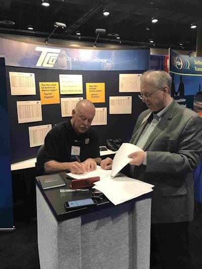 Randy Vernon, president of Big G Express (left), signs a contract with TCG on the exhibit floor at the TCA conference