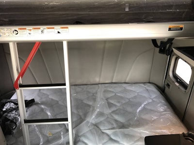 The upper bunk, capable of supporting 400 pounds, is accessed by an integrated telescopic ladder.