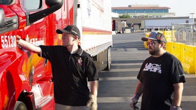 Josh England, C.R. England’s president, and Chad England, the fleet’s chief executive officer, conduct a pre-trip inspection before going out on a run. (Image Courtesy of C.R. England)
