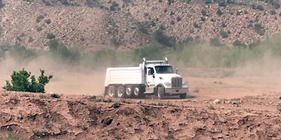 Peterbilt Model 567 truck riding on dirt road