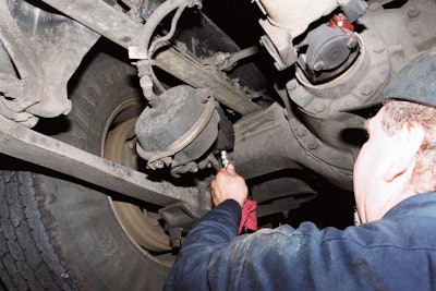 Technician checking lubrication on truck