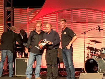 Steven Brain, middle, awarded the Rush Skills Tech Rode’s top prize by Rusty Rush and NASCAR driver Clint Bowyer.