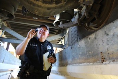 Inspector in pit inspecting a semi-truck