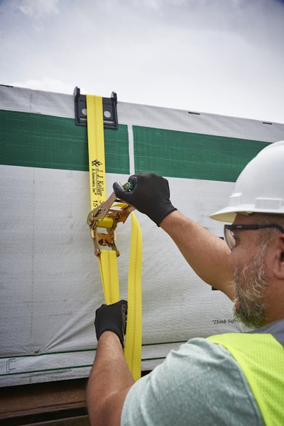 Man securing cargo on a flatbed semi-truck