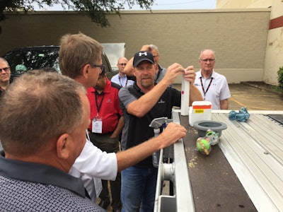 Velociti’s quality assurance manager, Pat Gober (center), shows how to install the Meritor Tire Inflation System (MTIS) at PSI’s manufacturing plant in San Antonio, Texas.