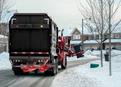 City Garbage and Recycle Truck Working picking up Garbage Bins in Residential Neighbourhood