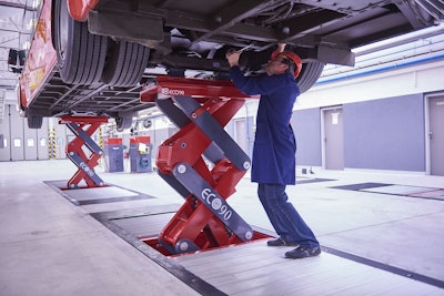 Mechanic working under truck on lift jack