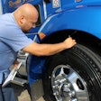 man checking tire tread depth