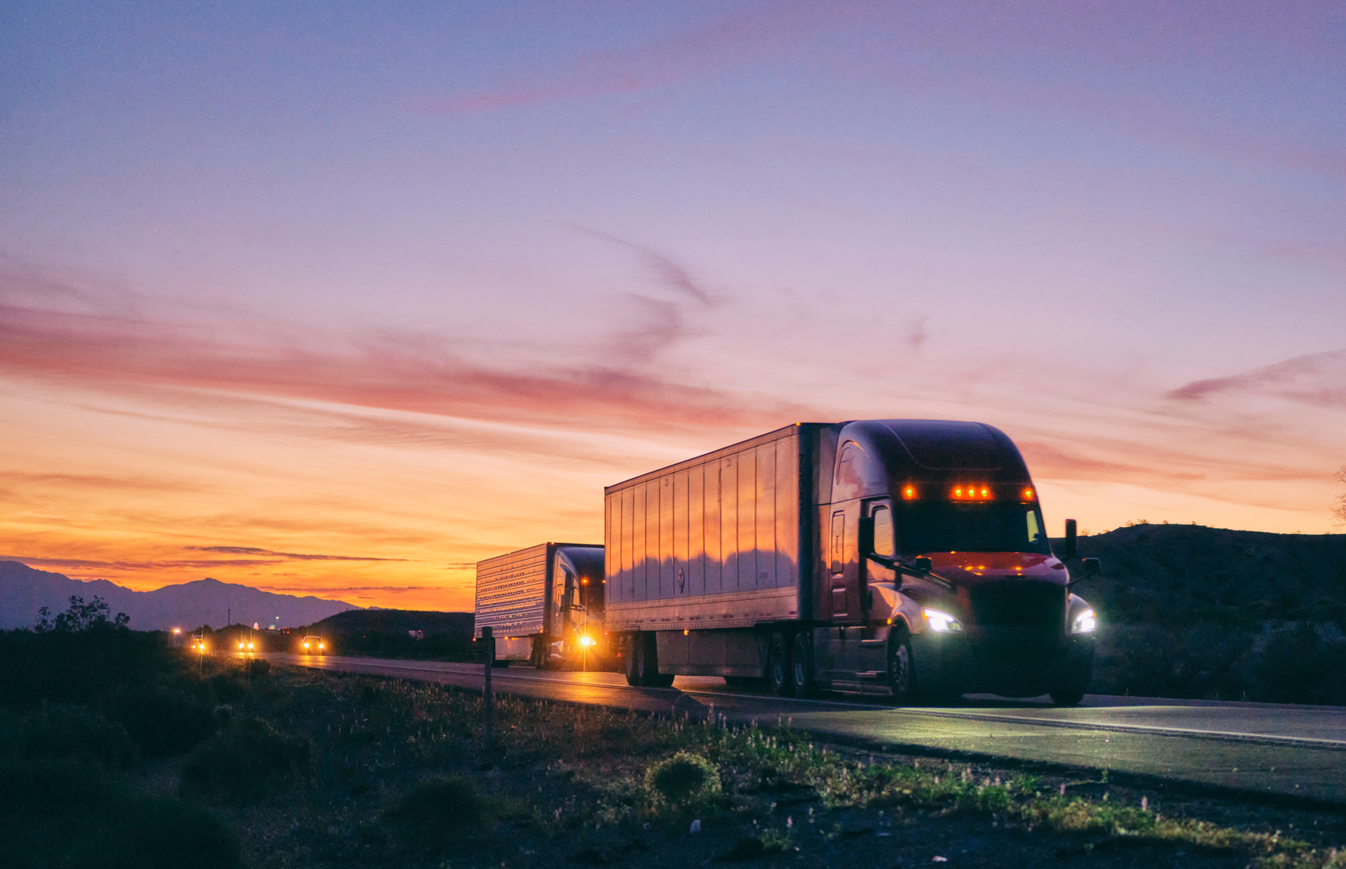 semi trucks on the highway at dusk
