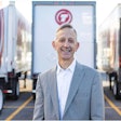 Keith Wilson, president of Titan Freight Systems, standing in front of Titan Freight semi-trucks