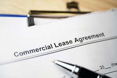 Commercial Lease Agreement form on a clipboard with a pen