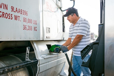 Man pumping fuel into a semi-truck
