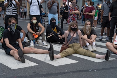 Protestors sitting in a crosswalk and blocking traffic on May 30, 2020