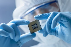 worker holding Semiconductor chip with gloves and safety gear