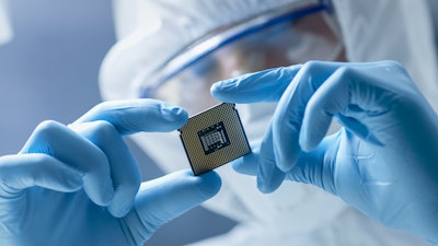 worker holding Semiconductor chip with gloves and safety gear