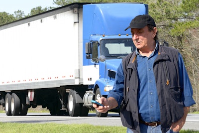 Truck driver on side of road using phone