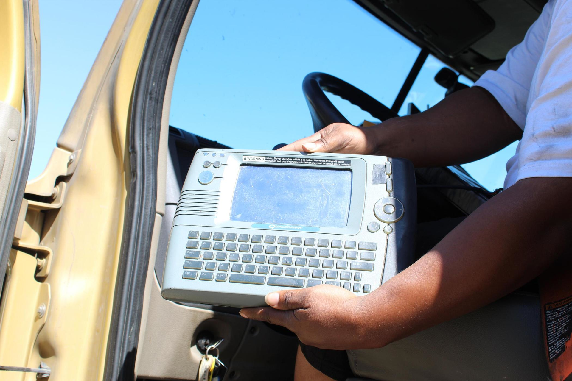 Person holding an ELD for inspection from the cabin of a truck