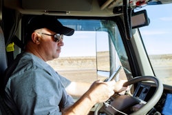 Truck driver behind the wheel looking at his phone