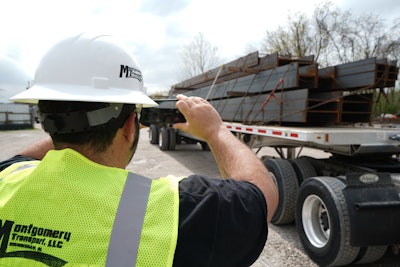 Montgomery Transport driver using his phone to take a picture of a load of steel beams